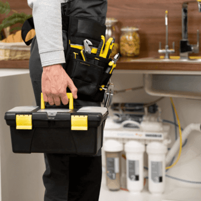 plumber fixing office water filtration system, under sink